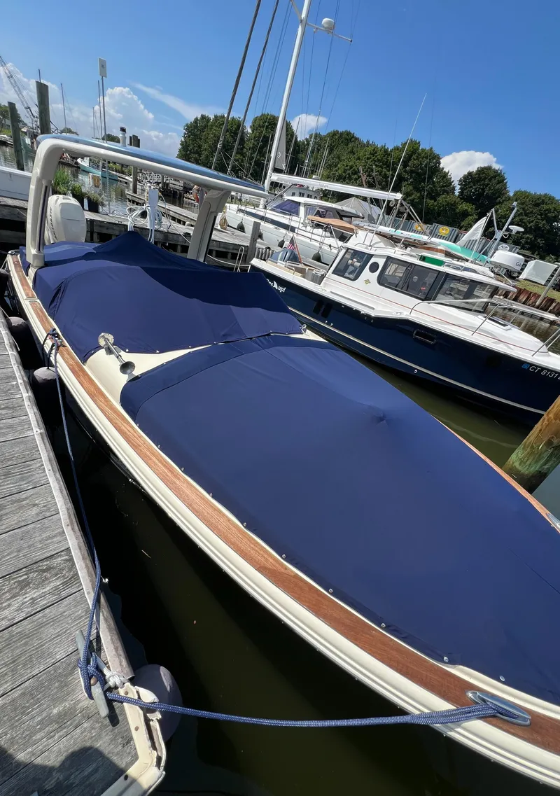 Slide: The Image of 2023 Chris-Craft Launch 28 GT boat docked, covered with a navy blue tarp. - 5