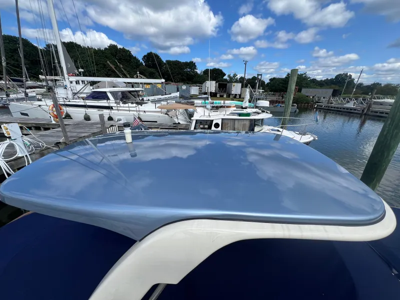 Slide: The Image of 2023 Chris-Craft Launch 28 GT boat docked at marina under blue sky. - 6