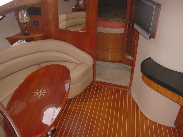 Slide: The Image of Interior of 2007 Regal 4460 Commodore yacht with elegant wood finish and cozy seating. - 16