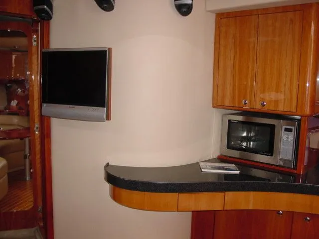 Slide: The Image of 2007 Regal 4460 Commodore yacht interior with TV, microwave, and wooden cabinetry. - 17