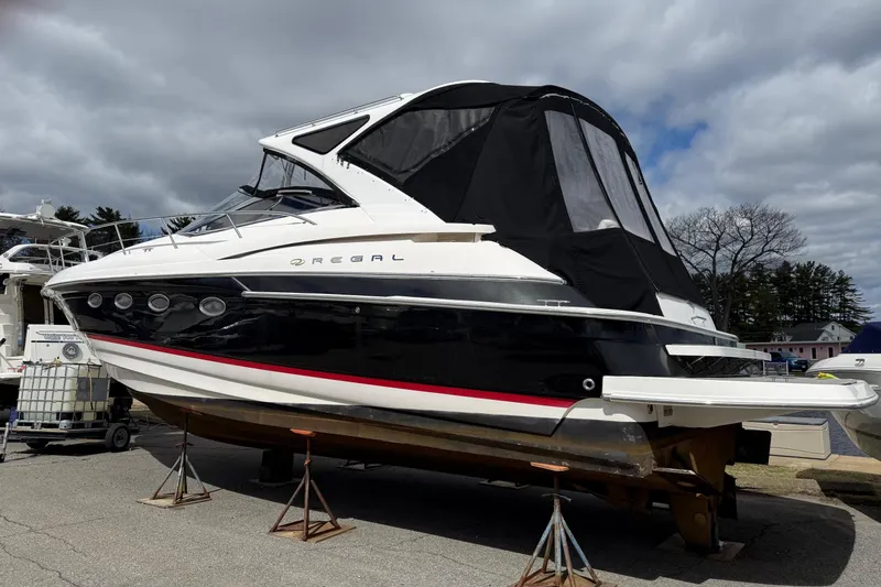 Slide: The Image of 2007 Regal Commodore 4460 yacht on stands, black and white exterior, cloudy sky background. - 26