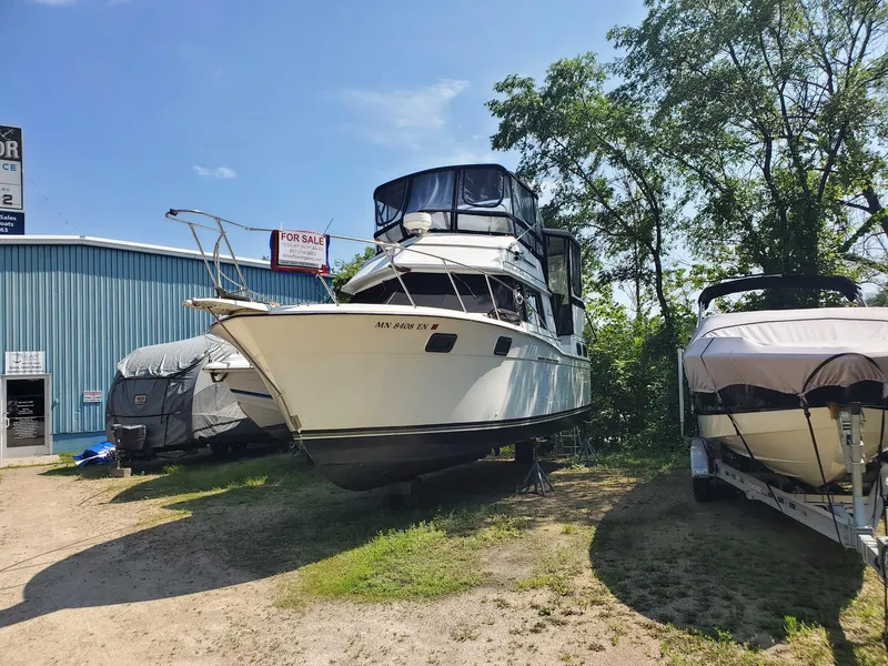 The Image of 1983 Carver 3207 AFT Cabin Motor Yacht on display outdoors near a blue building. - 0