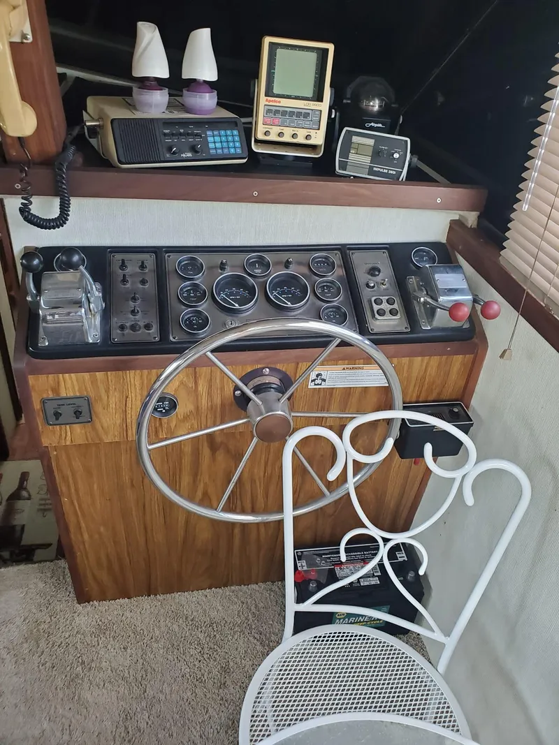 Slide: The Image of 1983 Carver 3207 AFT Cabin Motor Yacht helm with vintage controls and instruments. - 12