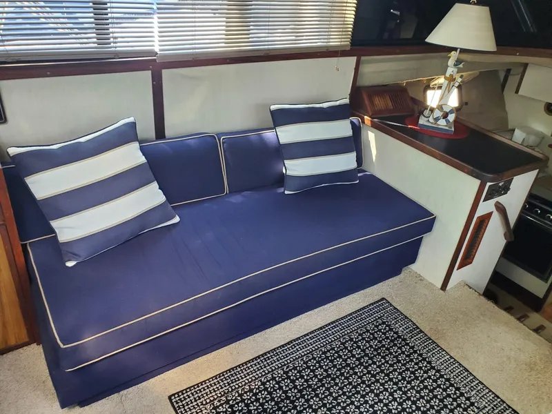 Slide: The Image of Interior of 1983 Carver 3207 AFT Cabin Yacht with blue sofa and striped cushions. - 20
