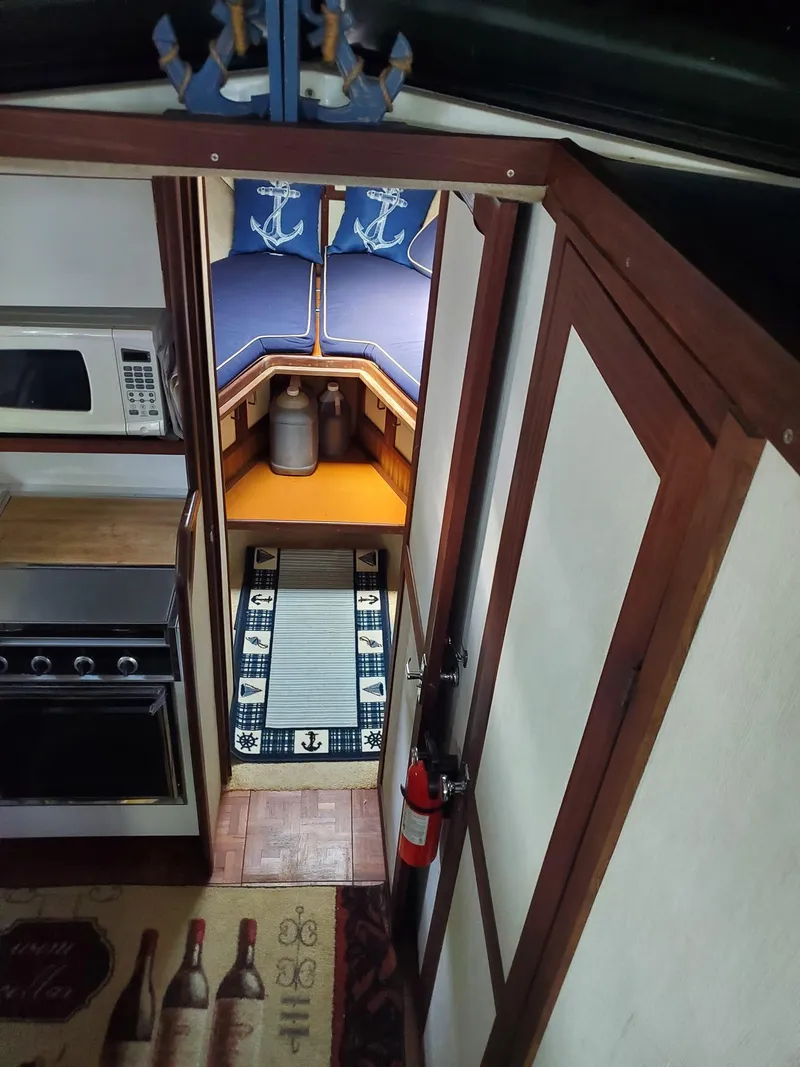 Slide: The Image of 1983 Carver 3207 AFT Cabin Motor Yacht interior with kitchen and cozy sleeping area. - 16