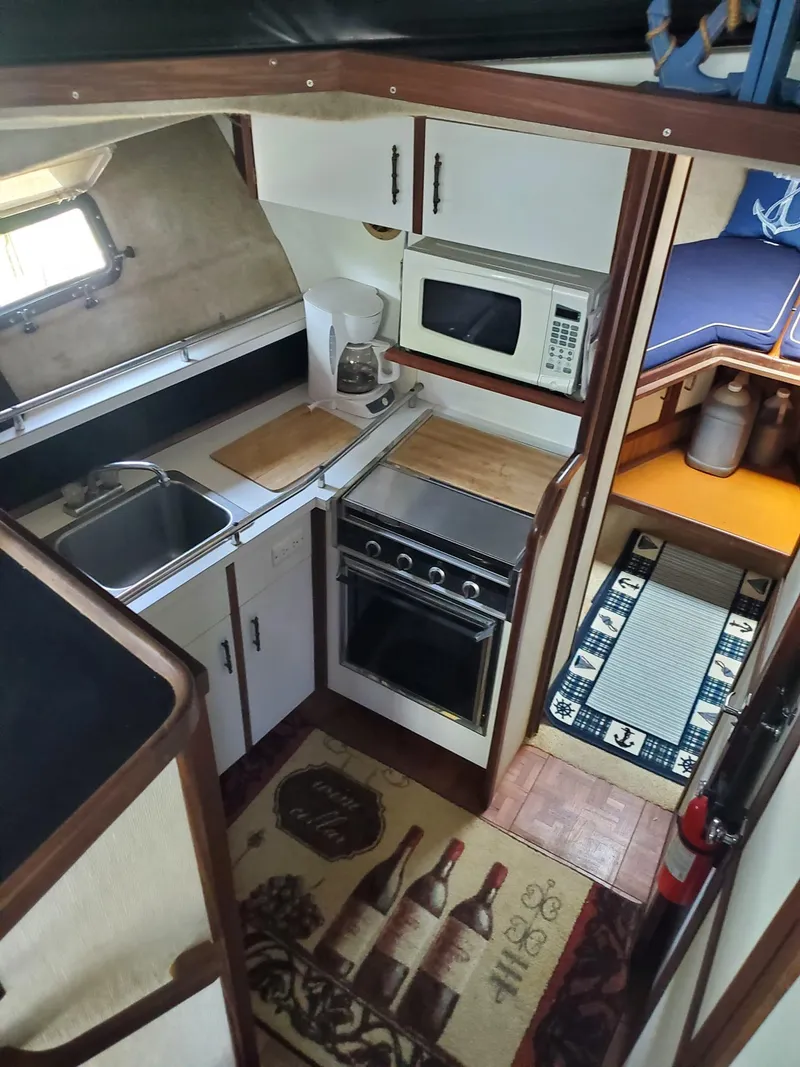 Slide: The Image of 1983 Carver 3207 AFT Cabin Motor Yacht interior with kitchen and cozy cabin area. - 4