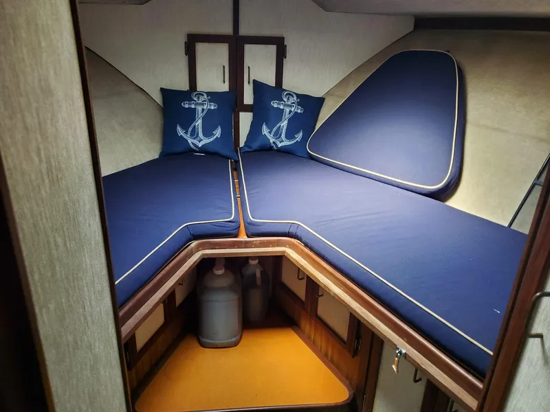 Slide: The Image of 1983 Carver 3207 AFT Cabin Motor Yacht interior with blue cushions and anchor-themed pillows. - 6