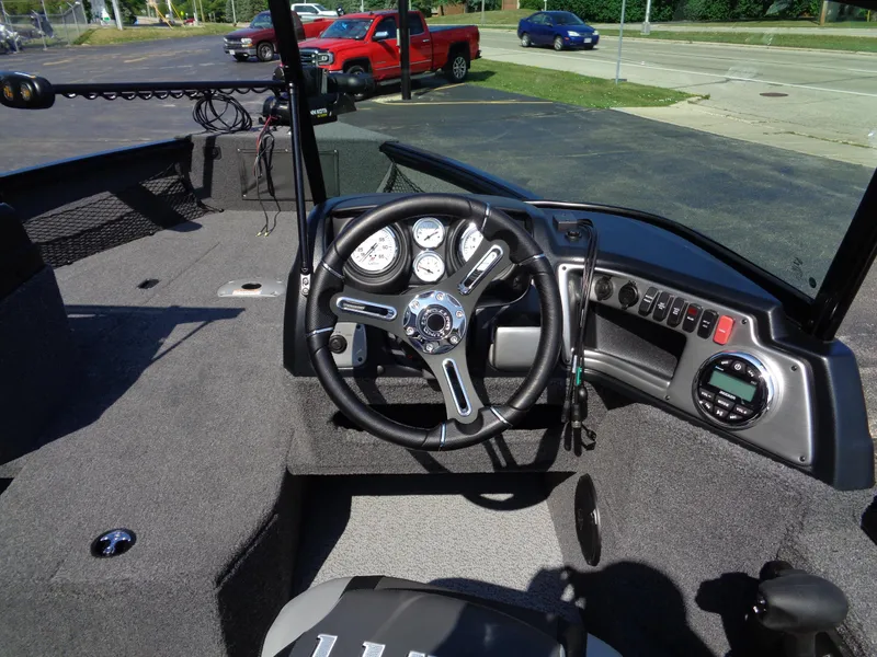 Slide: The Image of 2024 Lund 1875 Impact XS boat dashboard with steering wheel and gauges. - 11
