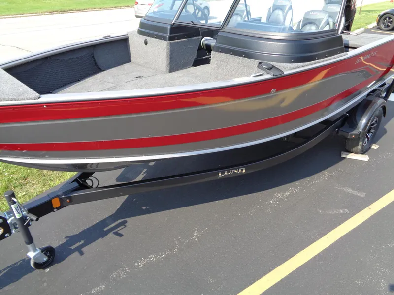 Slide: The Image of 2024 Lund 1875 Impact XS boat with red and gray exterior on a trailer. - 2