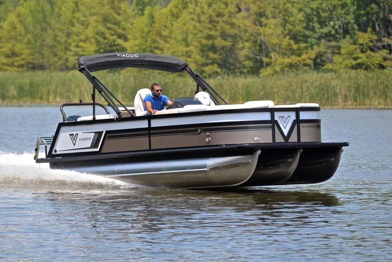 The Image of 2023 Viaggio Diamante 23 U Platinum pontoon boat cruising on a serene lake. - 1