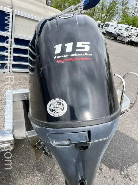 Slide: The Image of 2017 Bennington 23 RSR boat with 115 horsepower four-stroke engine, parked outdoors. - 23