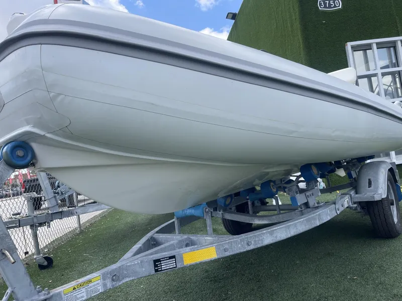 Slide: The Image of 2021 Apex A12 boat on trailer, displayed outdoors with blue sky background. - 16