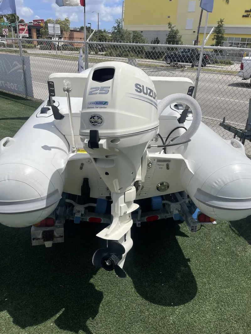 Slide: The Image of Inflatable boat with Suzuki 25HP motor, Apex A12 model, 2021, on display outdoors. - 4