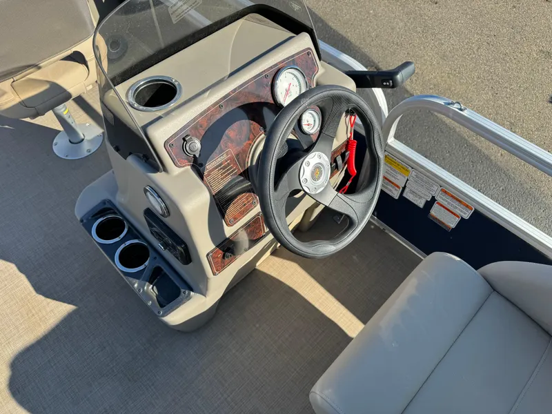 Slide: The Image of 2023 Sun Tracker Bass Buggy 18 DLX steering console with gauges and cup holders. - 10