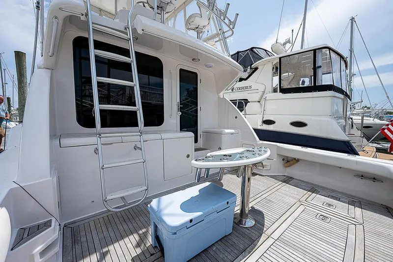 Slide: The Image of 2005 Bertram 450 Convertible yacht deck with ladder, table, and cooler. - 17