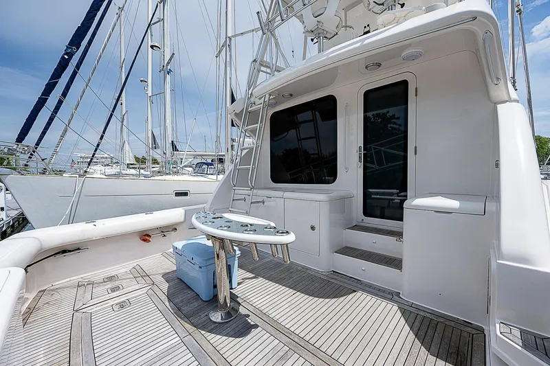 Slide: The Image of 2005 Bertram 450 Convertible yacht deck with seating and table, docked at marina. - 20