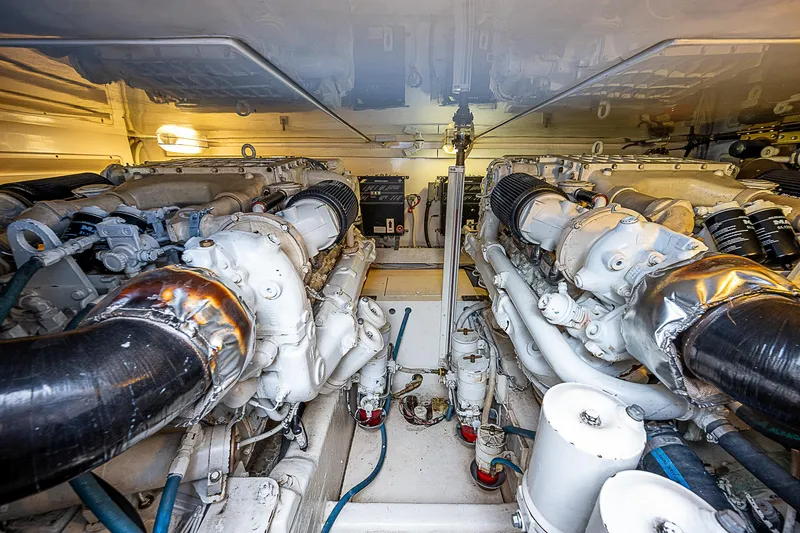 Slide: The Image of Engine room of 2005 Bertram 450 Convertible yacht, showcasing dual engines and mechanical components. - 25