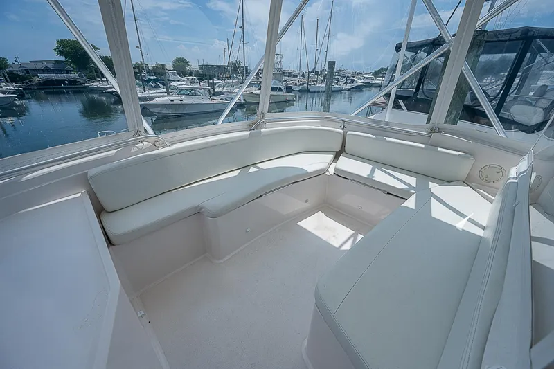 Slide: The Image of 2005 Bertram 450 Convertible yacht interior with white seating and marina view. - 33