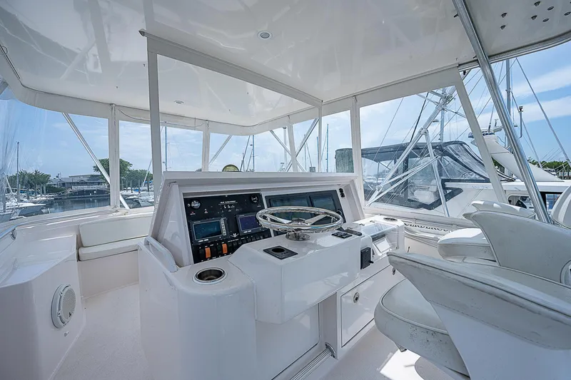 Slide: The Image of 2005 Bertram 450 Convertible yacht helm with modern controls and panoramic windows. - 34