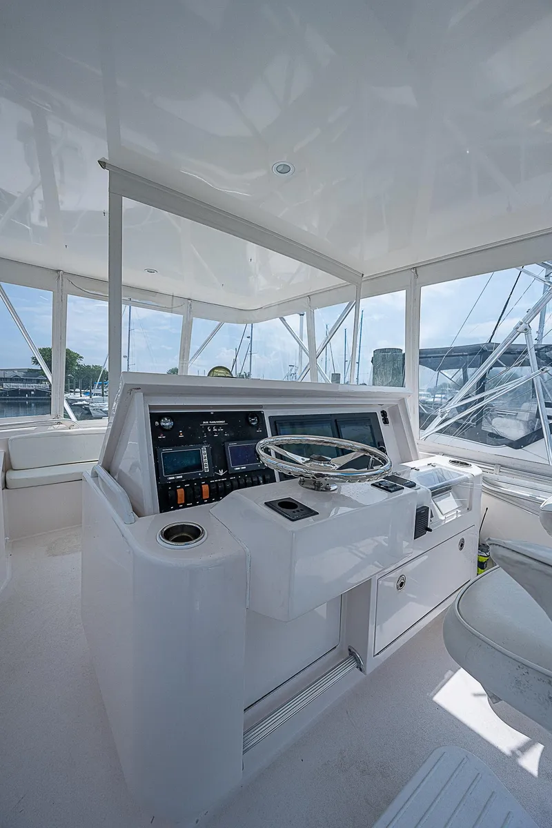 Slide: The Image of 2005 Bertram 450 Convertible yacht helm with modern controls and panoramic windows. - 35