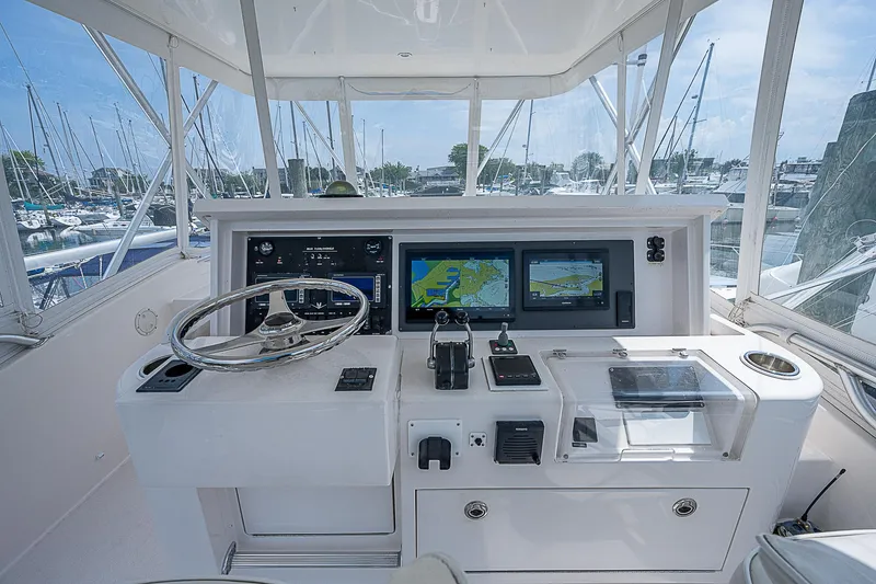 Slide: The Image of 2005 Bertram 450 Convertible yacht helm with navigation screens and controls. - 37