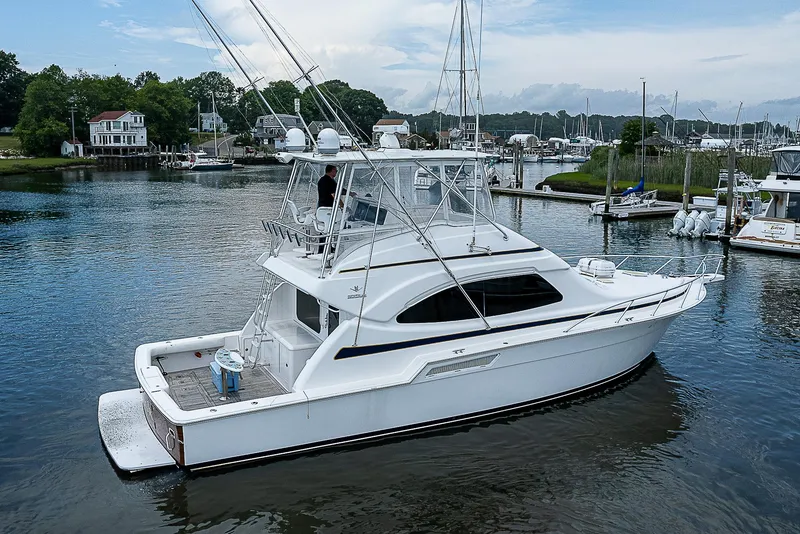 Slide: The Image of 2005 Bertram 450 Convertible yacht docked in a serene marina setting. - 7