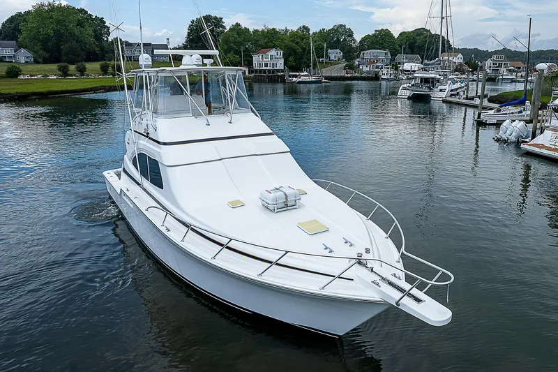 Slide: The Image of 2005 Bertram 450 Convertible yacht docked in a serene marina setting. - 8