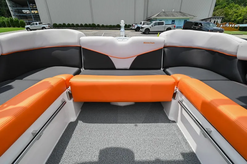 Slide: The Image of 2018 MasterCraft XT23 boat interior with orange and gray seating. - 16