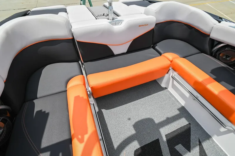 Slide: The Image of 2018 MasterCraft XT23 boat interior with orange and gray seating. - 17