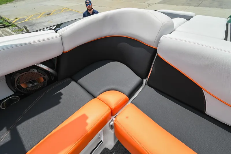 Slide: The Image of 2018 MasterCraft XT23 boat interior with orange and gray seating. - 18