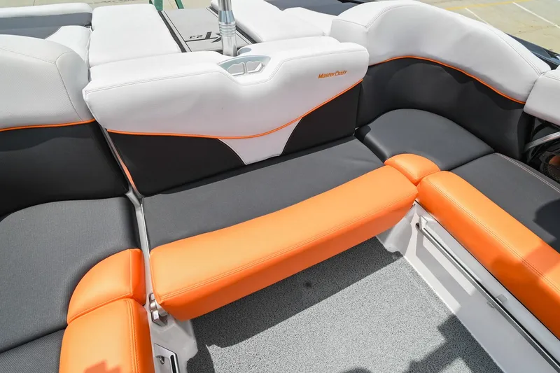 Slide: The Image of 2018 MasterCraft XT23 boat interior with orange and gray seating. - 22