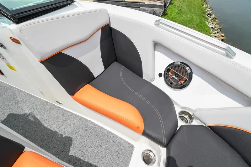 Slide: The Image of 2018 MasterCraft XT23 boat interior with orange and gray seating, speaker, and cup holders. - 39