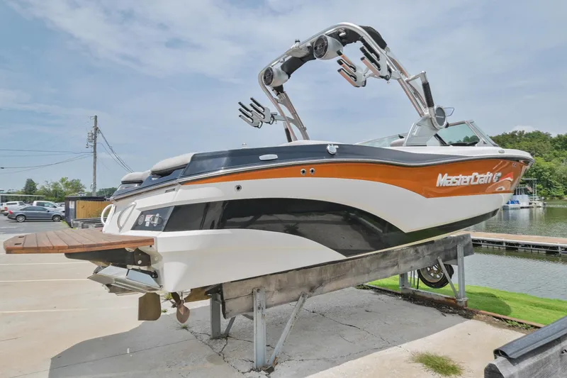 Slide: The Image of 2018 MasterCraft XT23 boat on display at a marina. - 4
