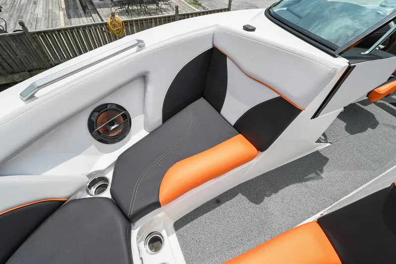 Slide: The Image of 2018 MasterCraft XT23 boat interior with orange and black seating, speaker, and cup holders. - 41