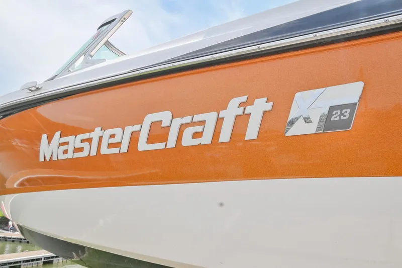 Slide: The Image of 2018 MasterCraft XT23 boat with orange and white exterior. - 7