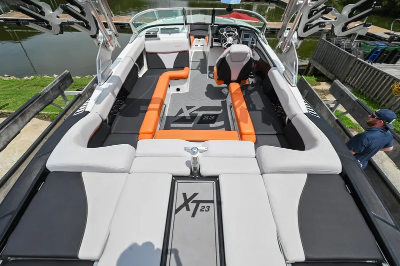 Slide: The Image of 2018 MasterCraft XT23 boat interior with orange and gray seating, sleek design. - 8