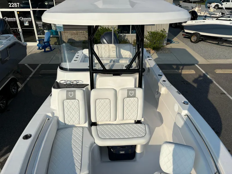 Slide: The Image of 2025 Sea Fox 248 Side Console boat with white seating and T-top in a showroom. - 16