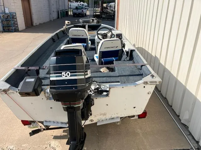 Slide: The Image of 1992 Starcraft FM 160C boat with 50 HP outboard motor, parked outdoors. - 2