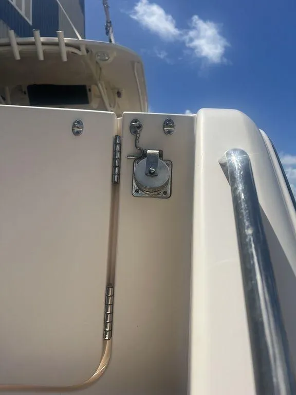 Slide: The Image of 2012 Grady-White 336 Canyon boat detail with latch and railing under blue sky. - 10