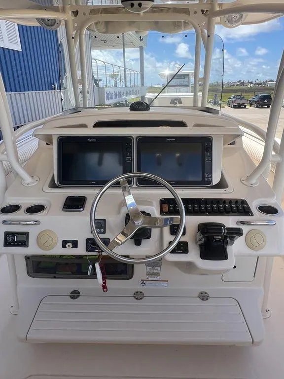 Slide: The Image of 2012 Grady-White 336 Canyon boat helm with dual screens and steering wheel. - 13