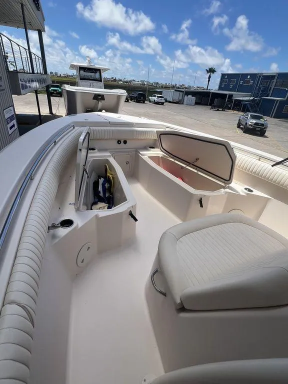 Slide: The Image of 2012 Grady-White 336 Canyon boat interior with open storage compartments, docked under a clear sky. - 21