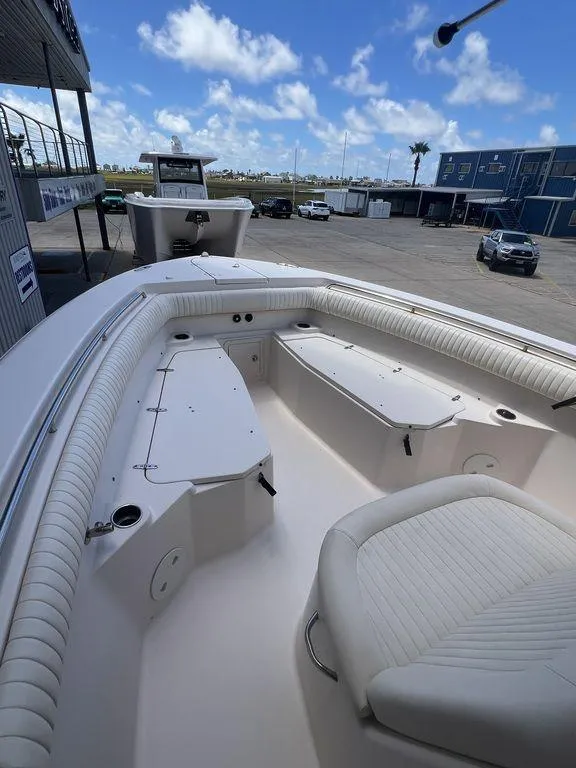Slide: The Image of 2012 Grady-White 336 Canyon boat interior with seating, docked under blue sky. - 23