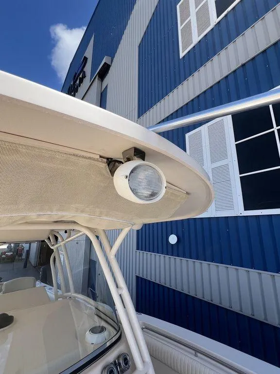 Slide: The Image of 2012 Grady-White 336 Canyon boat detail with spotlight, against blue building background. - 31