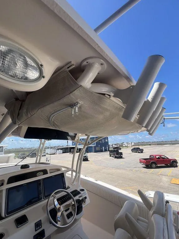 Slide: The Image of 2012 Grady-White 336 Canyon boat interior with steering wheel and rod holders. - 36