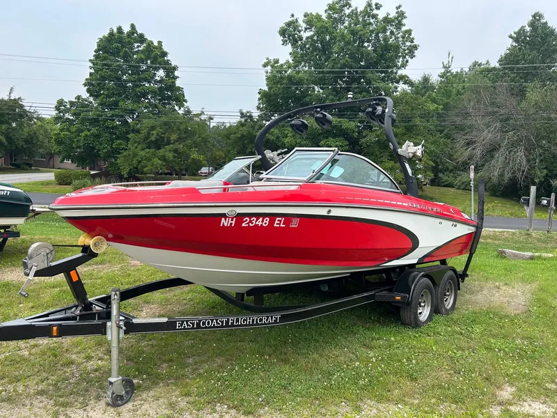 Slide: The Image of 2012 Centurion Enzo SV211 red boat on trailer, parked on grass. - 1