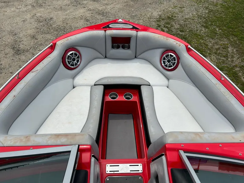Slide: The Image of 2012 Centurion Enzo SV211 boat interior with red and gray seating, cup holders, and speakers. - 7
