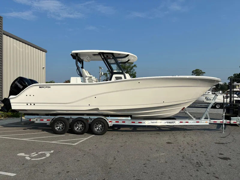 Slide: The Image of 2025 Sea Fox 328 Commander boat on trailer, parked outdoors. - 24