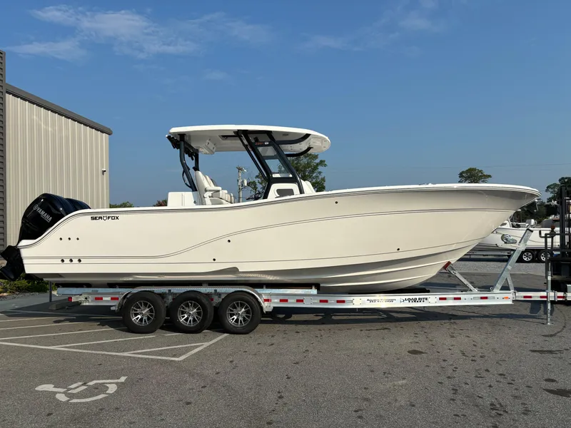 Slide: The Image of 2025 Sea Fox 328 Commander boat on trailer, parked outdoors under clear sky. - 25