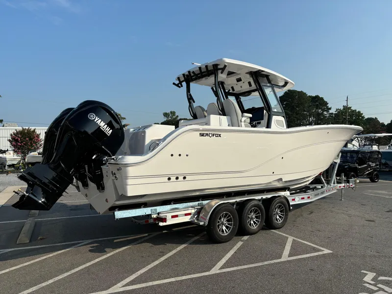 Slide: The Image of 2025 Sea Fox 328 Commander boat on trailer with Yamaha engines, parked outdoors. - 26