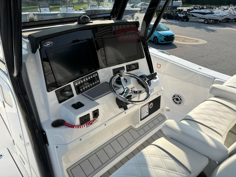 Slide: The Image of 2025 Sea Fox 328 Commander boat dashboard with dual screens and steering wheel. - 9